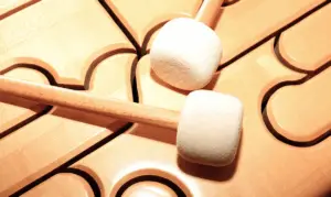 Zwei Filzschlägel auf einem hölzernen Klangbrett – Symbolbild für Musiktherapie.