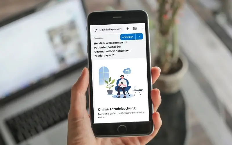 Smartphone mit geöffnetem Patientenportal der Gesundheitseinrichtungen Niederbayern zur digitalen Terminbuchung im BKH Landshut
